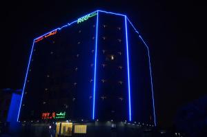 un edificio con luces azules por la noche en Reef Hotel Aparts (Tabasum Group), en Ajman