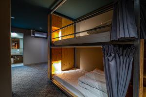 two bunk beds in a room with a bathroom at Wise Owl Hostels River Tokyo in Tokyo