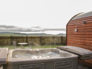 a bath tub with a table and chairs in a backyard at Stapeley Pod in Shrewsbury +5 photos