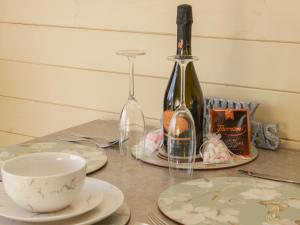 a table topped with plates and a bottle of wine at Stapeley Pod in Shrewsbury