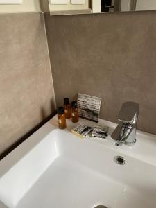 Un lavabo de baño blanco con un grifo y velas encima. en ViCo HomeSuite, en Milazzo