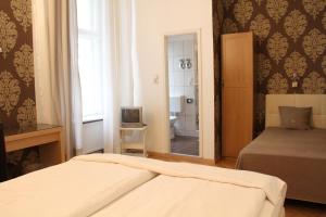 a bedroom with a bed and a television and a mirror at Hotel Garni Kleist am Kurfürstendamm in Berlin