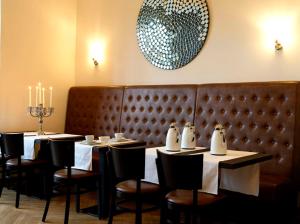 a dining room with tables and chairs and a chandelier at Hotel Garni Kleist am Kurfürstendamm in Berlin
