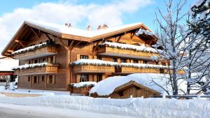 a large wooden building covered in snow at Hotel des Alpes Superieur in Gstaad