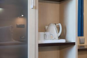 a tea kettle and cups sitting on a shelf at Holiday Inn Express Porto Exponor, an IHG Hotel in Leça da Palmeira