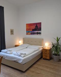 1 cama en un dormitorio con 2 lámparas y una pintura en la pared en 007 Studio Apartment Madrid 30m2, en Klagenfurt