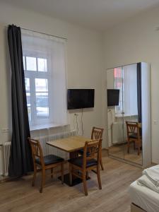 Una sala de estar con una mesa y sillas y un espejo. en 007 Studio Apartment Madrid 30m2, en Klagenfurt