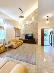 a living room with two couches and a flat screen tv at Huge & Private Villa In Kibbutz Dafna in Metsudat Menahem Ussishkin Alef +17 photos