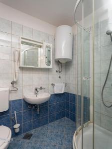 a bathroom with a sink and a glass shower at Apartments Hostin Roža Duga Uvala in Krnica