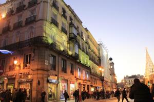 um grupo de pessoas andando por uma rua em frente aos edifícios em Hostal Ana Belen em Madri