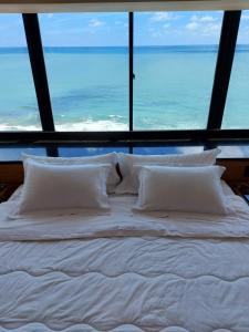 uma cama num quarto com vista para o oceano em Hotel Euro Suíte Recife Boa Viagem no Recife