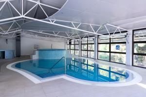 a swimming pool in a building with windows at Hotel Flores in Poreč