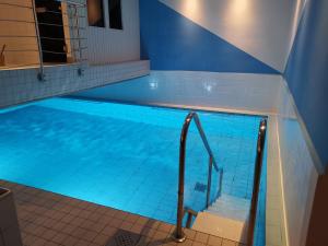 a swimming pool with a stairway leading into the water at Akzent Hotel Körner Hof in Dortmund
