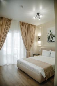 una camera da letto con un grande letto bianco e tende di Dream Hotel a Izmaïl