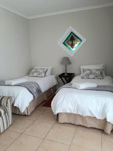 2 camas num quarto com piso em azulejo em De Graaff Manor em Graaff-Reinet