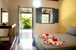 a room with a bed with flowers on it at Pousada Lagoa Da Pedra in Imbassai