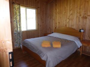 1 dormitorio con 1 cama con 2 toallas amarillas en Mansión Carhuello, en Pucón