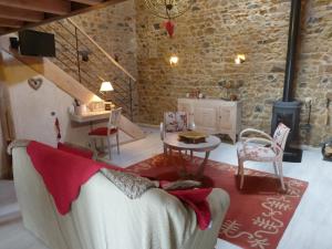 Le Clos du Merle في Savigny: غرفة معيشة مع أريكة بيضاء وطاولة