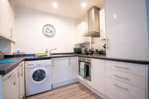 a kitchen with white cabinets and a washer and dryer at No4 Nursery Convent in Mansfield