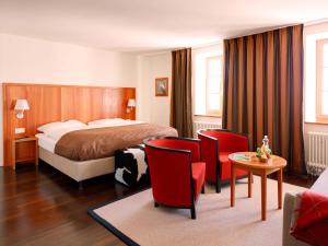 a hotel room with a bed and a table and chairs at Hotel Pilatus-Kulm in Lucerne