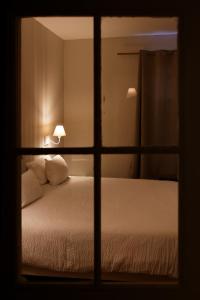 a view of a bed through a window at Appart'Hôtel Sainte Trinité in Troyes