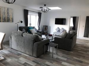 uma sala de estar com dois sofás e uma televisão em 2 Barn Cottages em Whitchurch