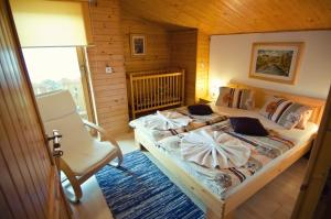 a bedroom with a large bed and a chair at Rodinné apartmány Alpinka in Oščadnica