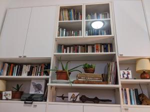 una mensola piena di libri di Il Nido - Casa Vacanze & Galleria d'Arte a Orbetello