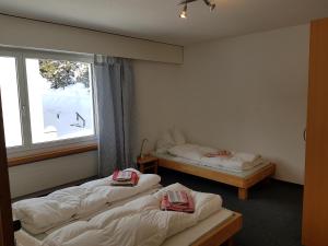 2 Betten in einem Zimmer mit Fenster in der Unterkunft Seegarten A (361 Ku) in Lenzerheide