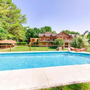 a swimming pool in front of a house at Posada La Escondida in Villa General Belgrano