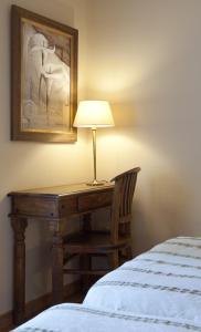 a bed in a room with a lamp on top of it at Hotel Don Carlos Cáceres in Cáceres