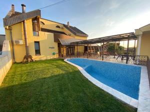 a villa with a swimming pool in front of a house at Pensiunea Imperial in Târgu-Mureş