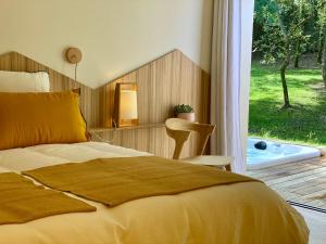 a bedroom with a bed and a window with a tub at Chambres avec Jacuzzi privatif - Kassiopée Bed & Spa in Albi