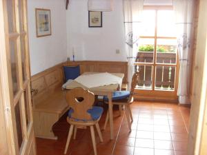Zimmer mit einem Tisch, Stühlen und einem Fenster in der Unterkunft Ferienwohnung Schartner in Eggstätt