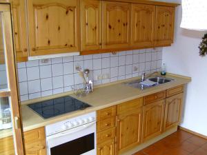 a kitchen with wooden cabinets and a sink at Ferienwohnung Schartner in Eggstätt