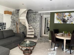 a living room with a couch and a spiral staircase at La Salamandre de l Olivier - le Mimosa in Aubignosc