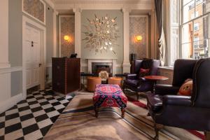 a living room with chairs and a fireplace at Home Grown Club in London