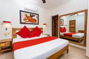 1 dormitorio con 2 camas y almohadas rojas en Albachiara Hotel - Las Terrenas, en Las Terrenas