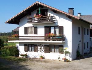 una casa blanca con flores en las ventanas en Haus Strobl en Gstadt am Chiemsee