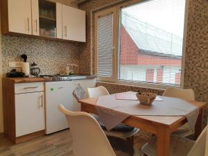 a kitchen with a wooden table and a table and chairs at Apartma Cerknica in Cerknica