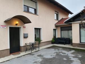a building with a table and chairs in a parking lot at Apartma Cerknica in Cerknica