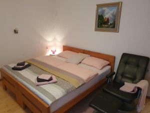 a bedroom with a bed and a black chair at Apartma Cerknica in Cerknica