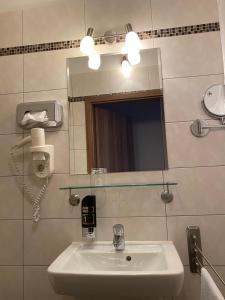 a bathroom with a sink and a mirror at Hotel Isabella in Frankfurt/Main