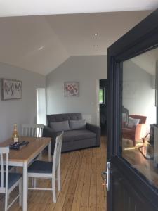 Cosy stylish 1-Bed Apartment in South Armagh في Cullyhanna: غرفة معيشة مع أريكة وطاولة
