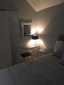 Cosy stylish 1-Bed Apartment in South Armagh في Cullyhanna: غرفة نوم بسرير ومكتب ومرآة