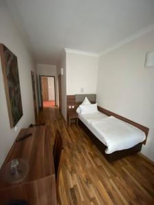 - une chambre avec un lit et une table en bois dans l'établissement Hotel Isabella, à Francfort-sur-le-Main