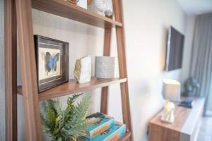 a book shelf with books and a blue butterfly on it at Lovely 5-Bed House in centre of Bicester Village in Bicester