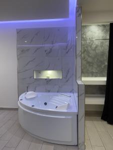 a white tub in a bathroom with a marble wall at Arizona Motel in Castel Volturno