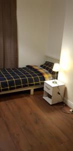 a bedroom with two beds and a table with a lamp at Greater Manchester Immaculate Cozy Home in Oldham