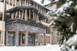 a building with snow falling in front of it at LaMonte Premium Apartments by Feuerstein in Colle Isarco